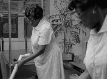 A black and white photo of two Black women cleaning