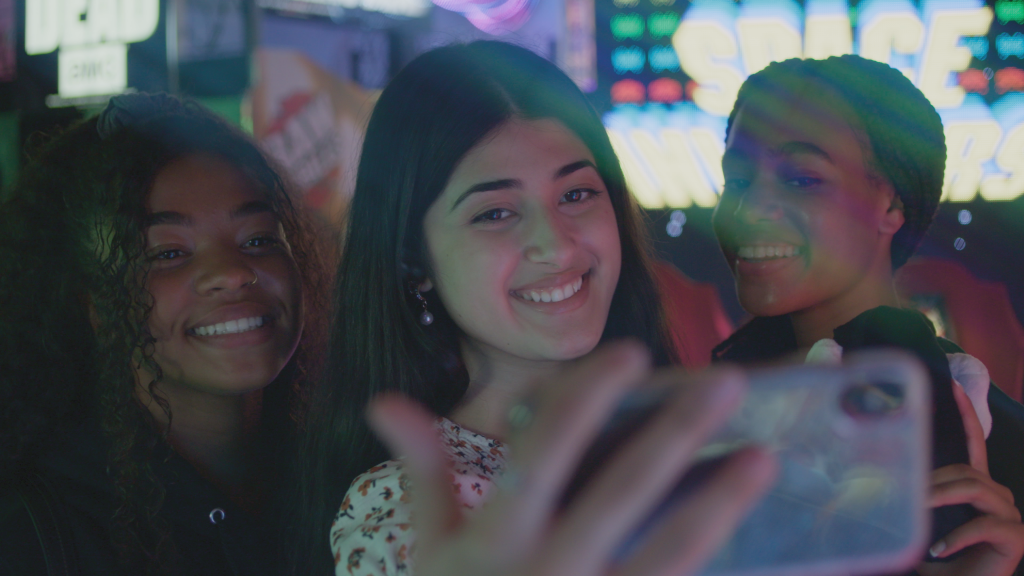 A group of girls take a selfie with a vibrant background