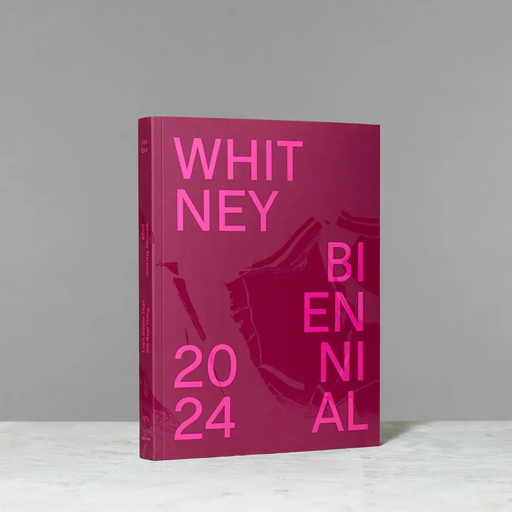 The 2024 Whitney Biennial program book standing on a countertop